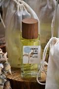 Small amber essential oil bottle with a wooden cap on a wood slice, surrounded by burlap sacks (cosmetic product).