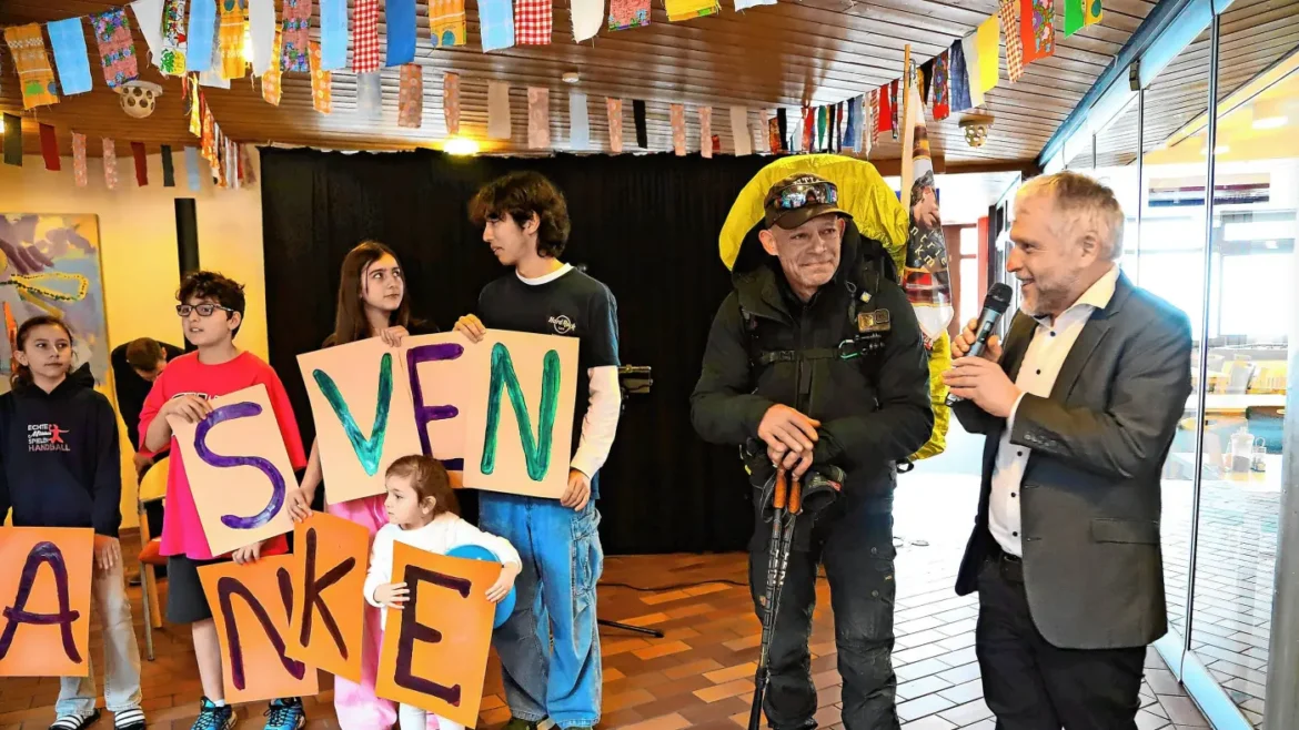 Children hold colorful letter boards spelling 'SVENKE' as a man in protective gear and a host speak at a festive event.