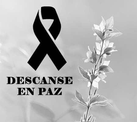 Black mourning ribbon with the Spanish phrase 'Descansa en paz' next to a sprig of leaves, as a death tribute.