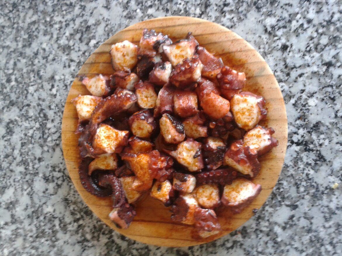 Ración de pulpo á feira servida sobre plato de madera