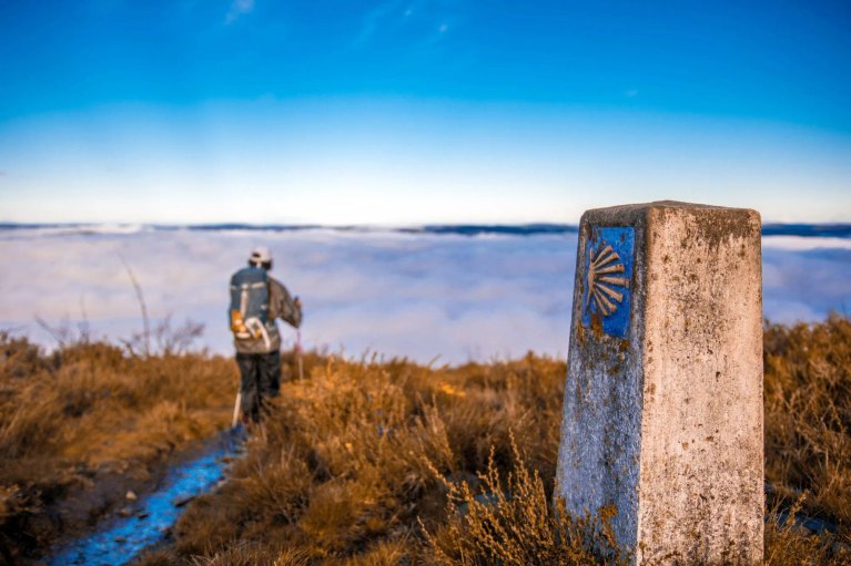 Peregrino caminando sobre las nubes en el Camino Primitivo